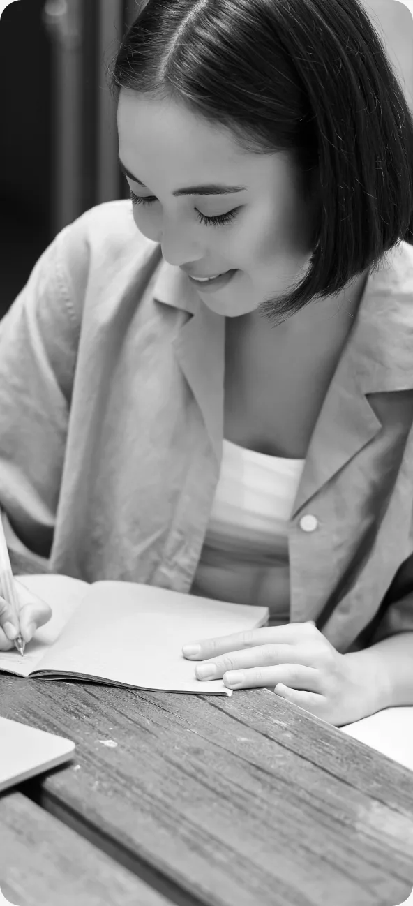 Estudante escrevendo em caderno sobre mesa