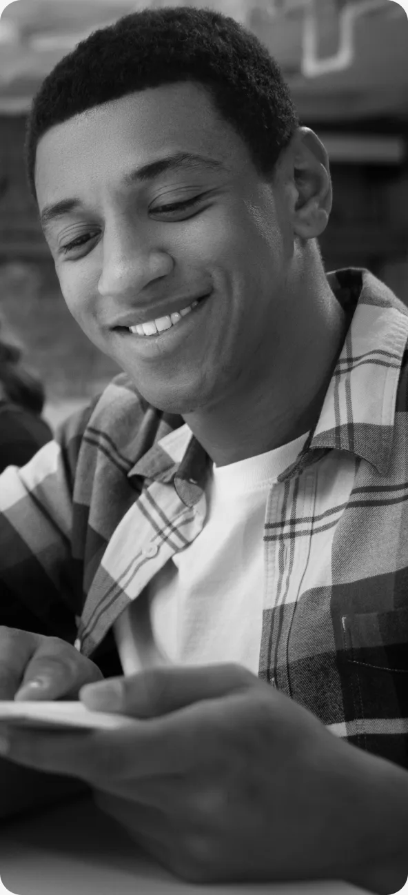 Estudante sorrindo olhando para celular
