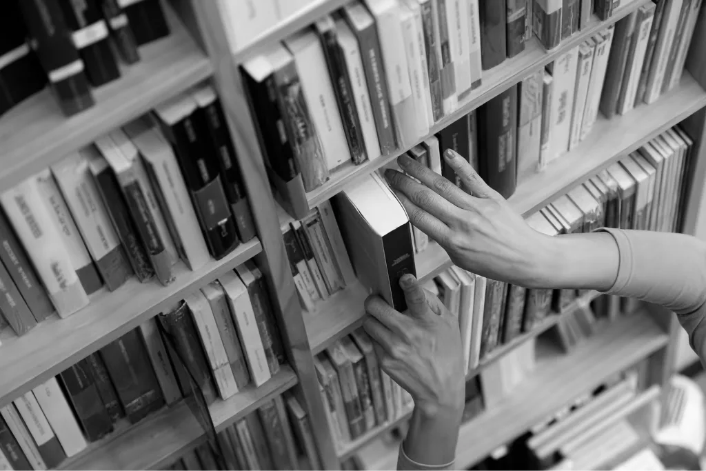 Pessoa retirando livro de uma estante